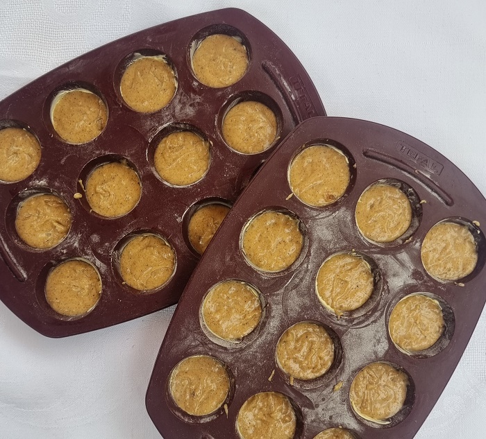 Versement de la p&acirc;te &agrave; pain d'&eacute;pices &agrave; mi-hauteur dans les moules en silicone